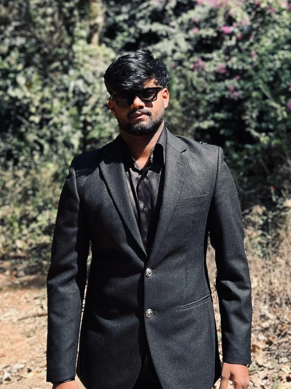 man standing outdoor in black suit